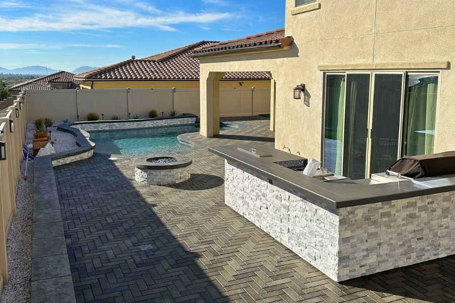 A selection of outdoor hardscape features showcasing different types of pavers, including concrete, brick, and natural stone