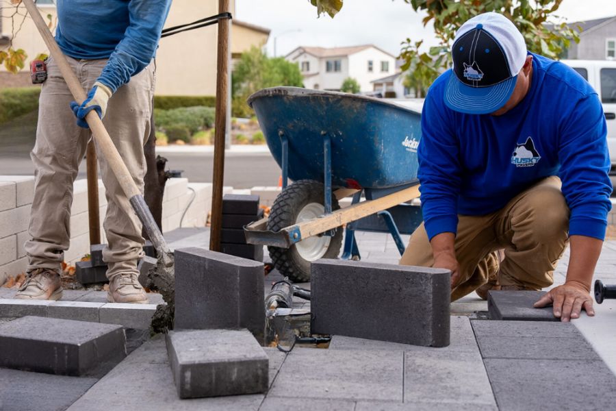 Professional team installing interlocking driveway pavers, showcasing the advantages of expert installation.